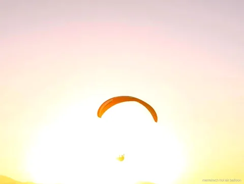 Tandem-Gleitschirmflug über dem Atlas-Gebirge bei Sonnenuntergang